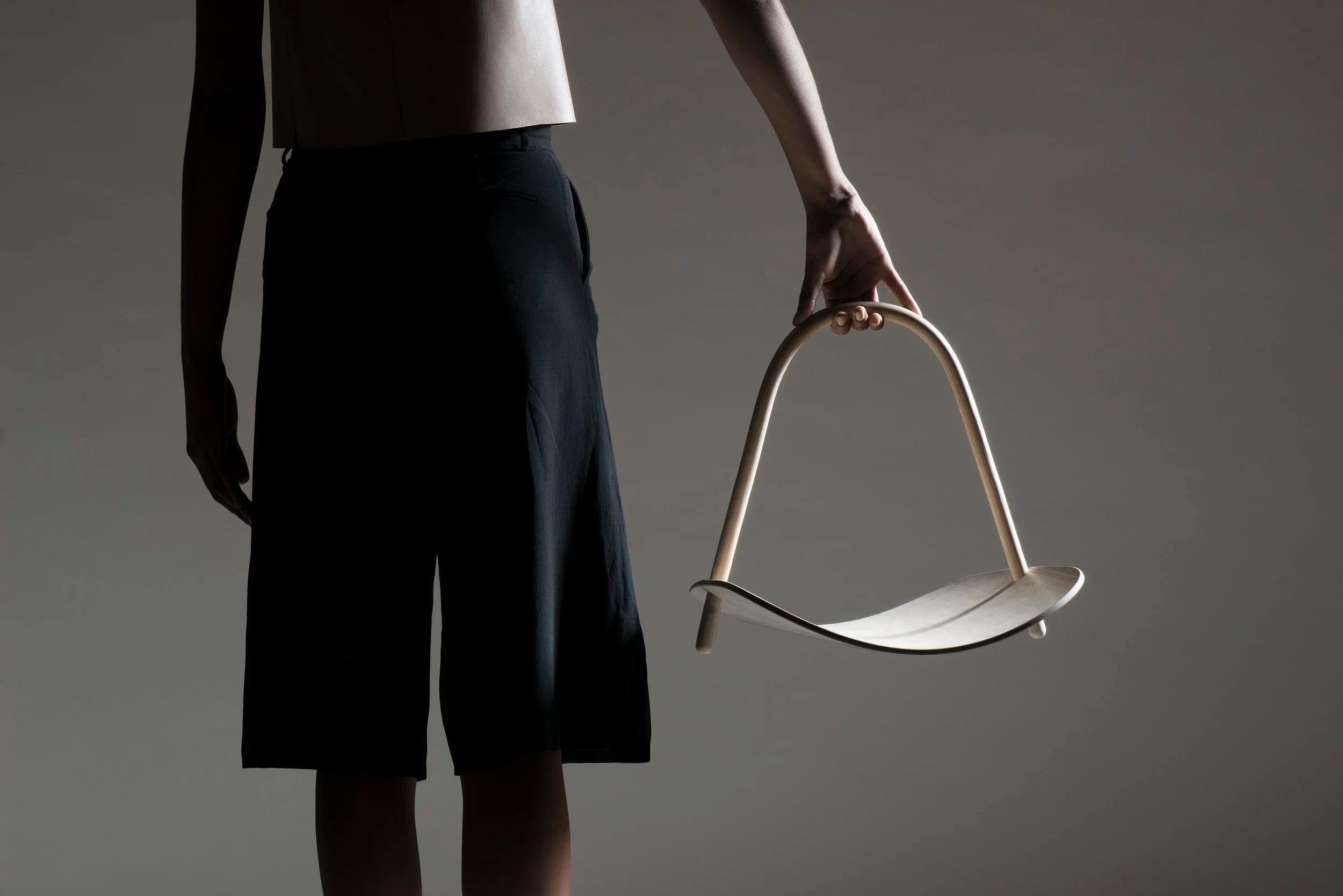 Person holding a modern basket against a gray background