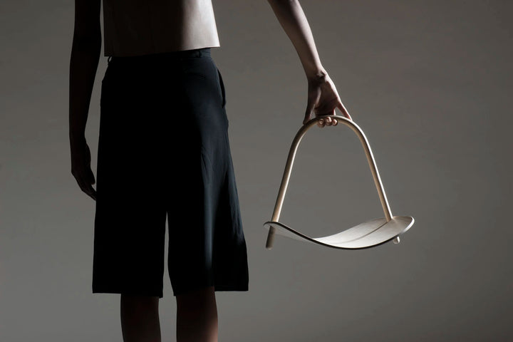 Person holding a modern basket against a gray background