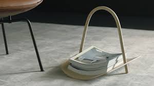 Stack of books on a curved wooden stand with a chair in the background