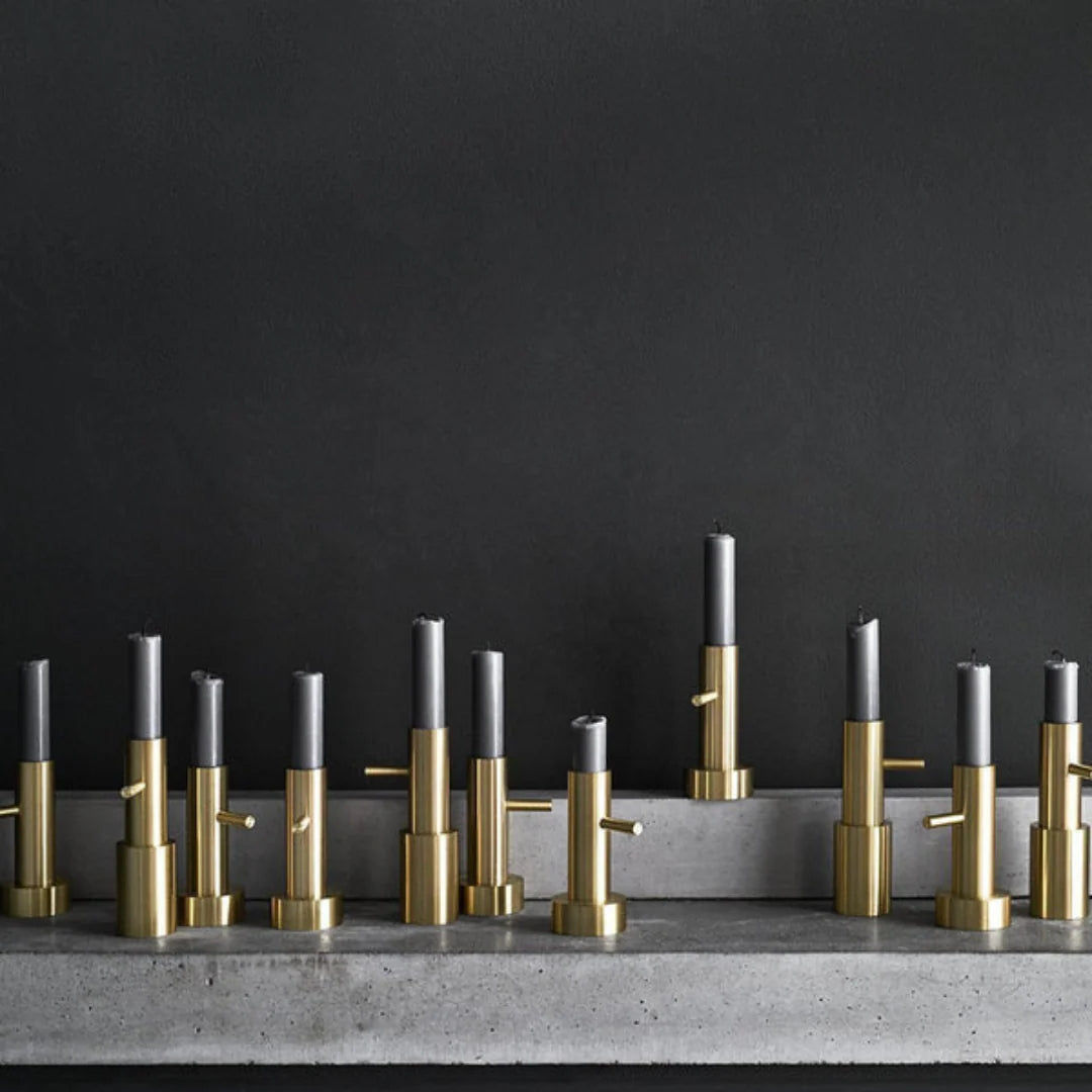 Row of gold and silver candle holders on a dark background