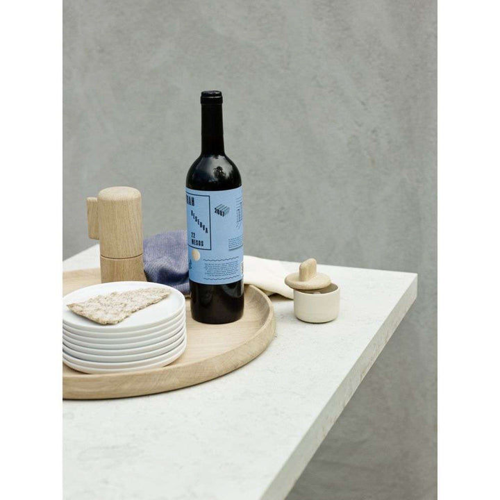 Wine bottle with a blue label on a white surface with gray background