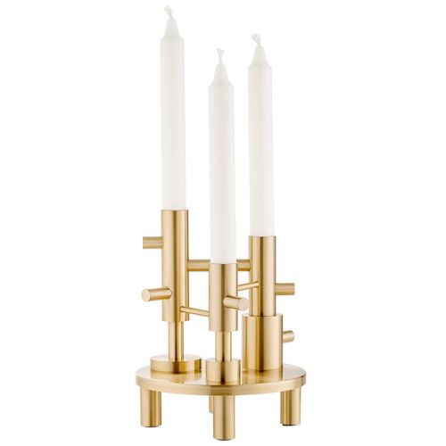 Brass candle holder with three white candles on a white background