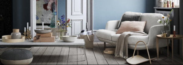 Modern living room with a gray sofa, coffee table, and decorative items.