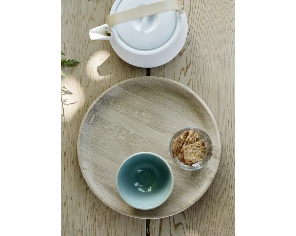 Tea set with a teapot, cup, and small bowl on a wooden tray.